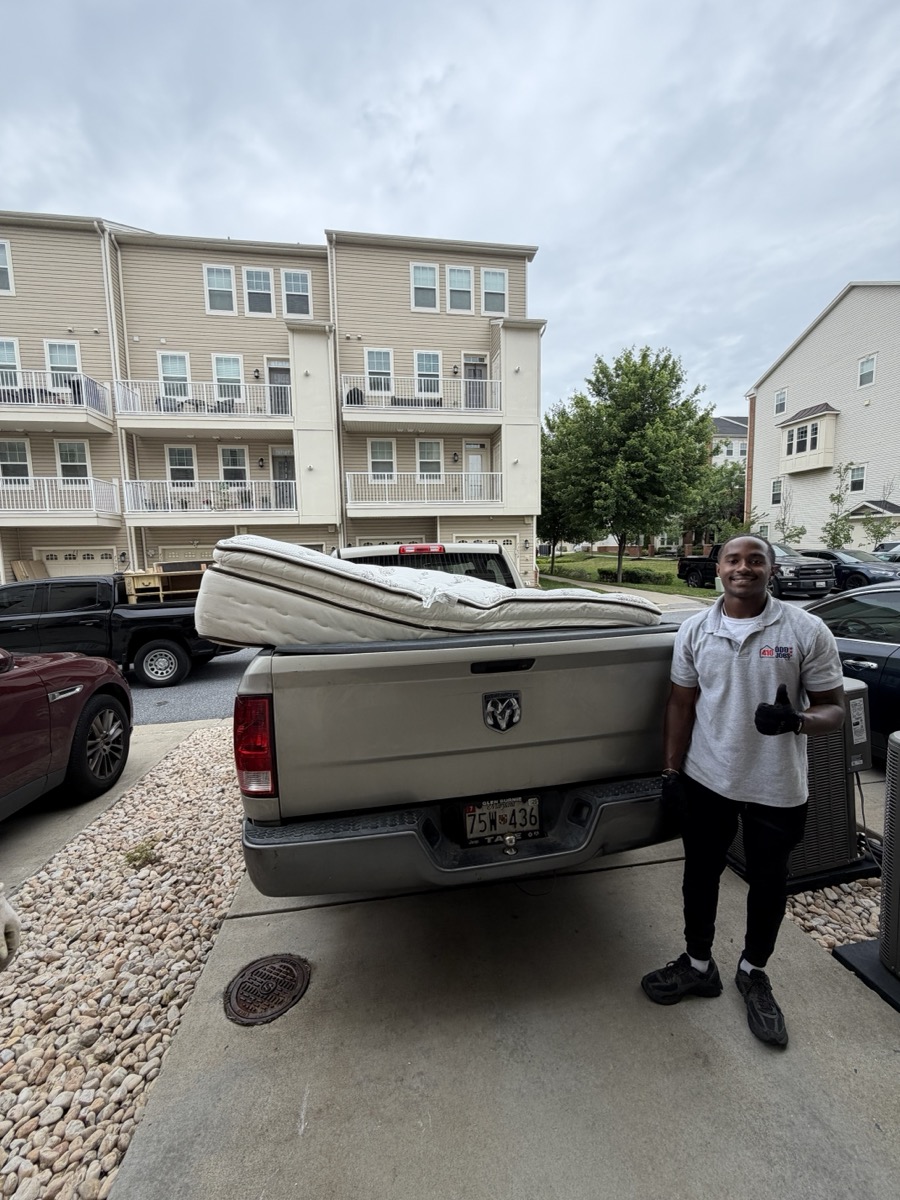 410 Odd Jobs team member with a mattress loaded on a pickup truck
