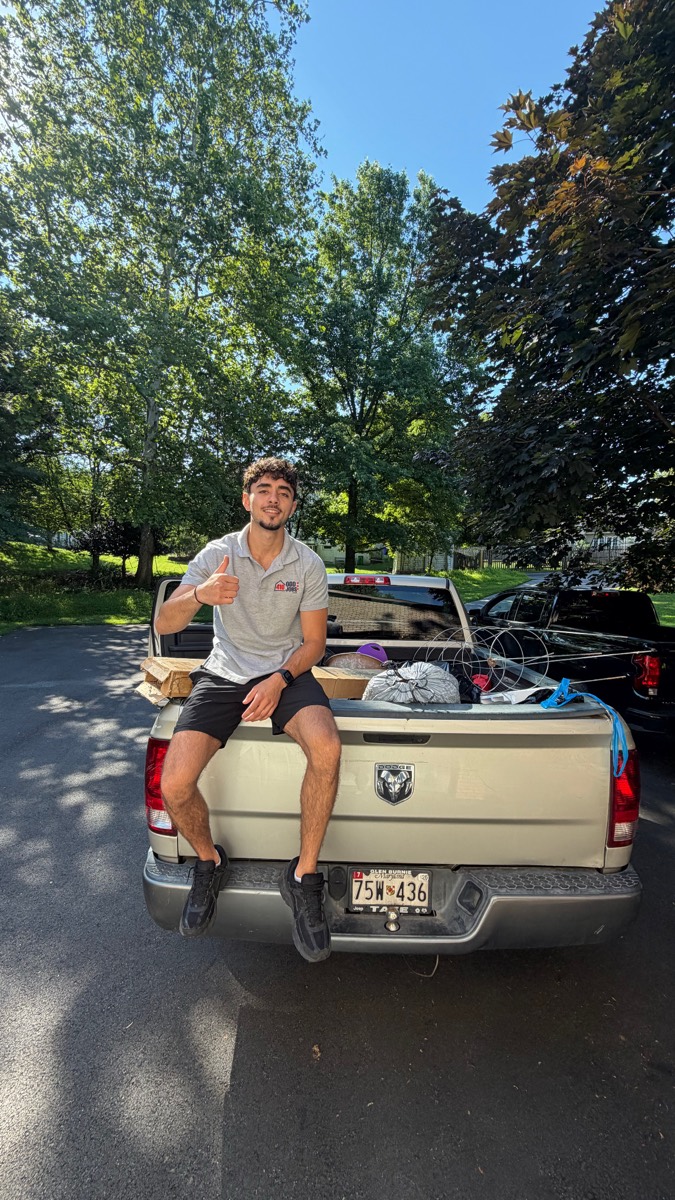 Ahmad on the tailgate of a pickup truck loaded with debris