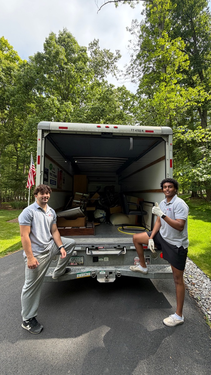 Two 410 Odd Jobs team members at the back of a loaded moving truck