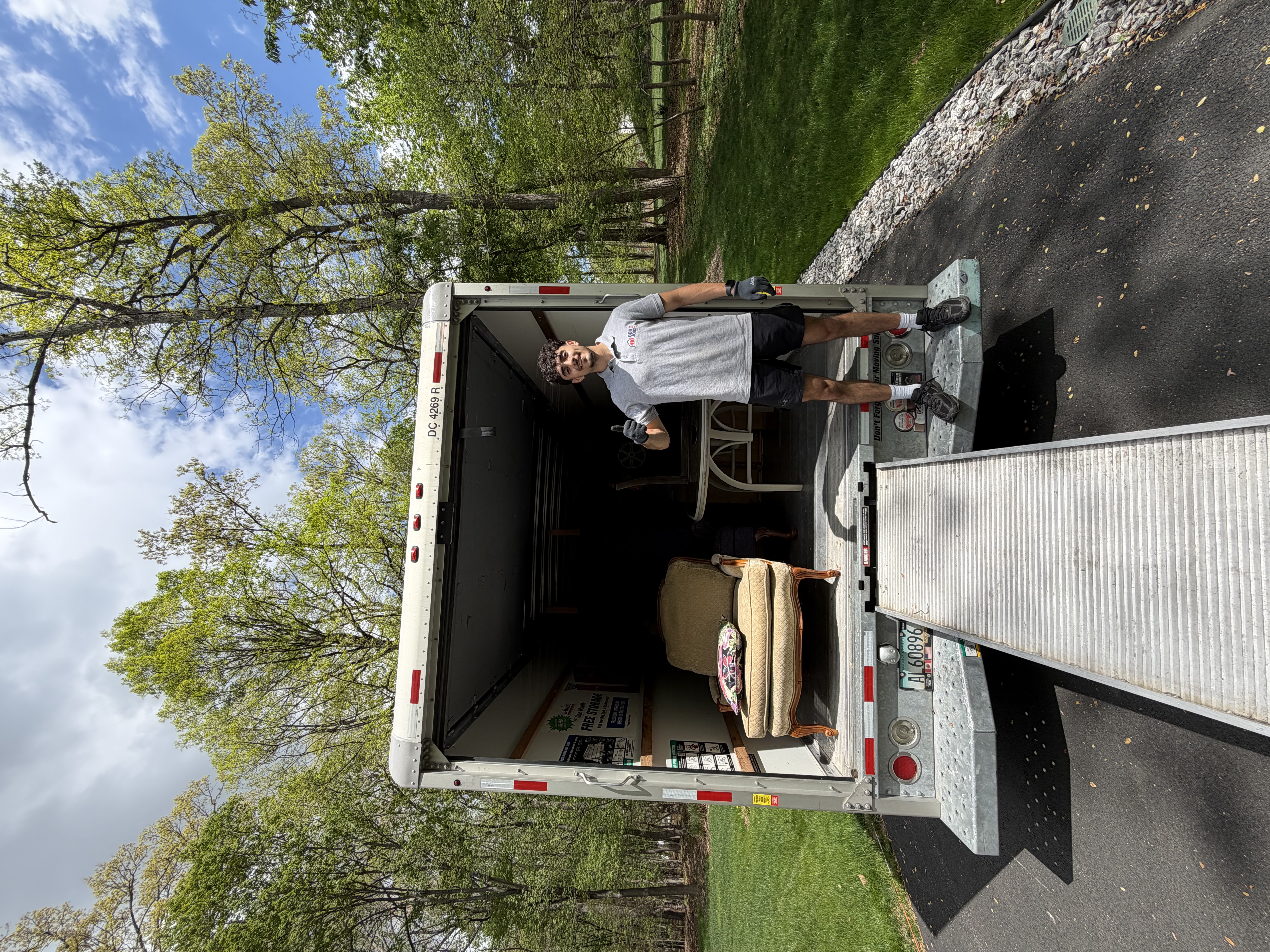 Ahmad standing by a 410 Odd Jobs truck filled with yard waste